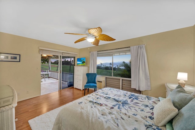 bedroom featuring ceiling fan, light hardwood / wood-style floors, access to outside, and a wall mounted AC