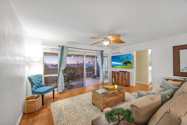 living room featuring ceiling fan, a wall mounted air conditioner, and light hardwood / wood-style floors