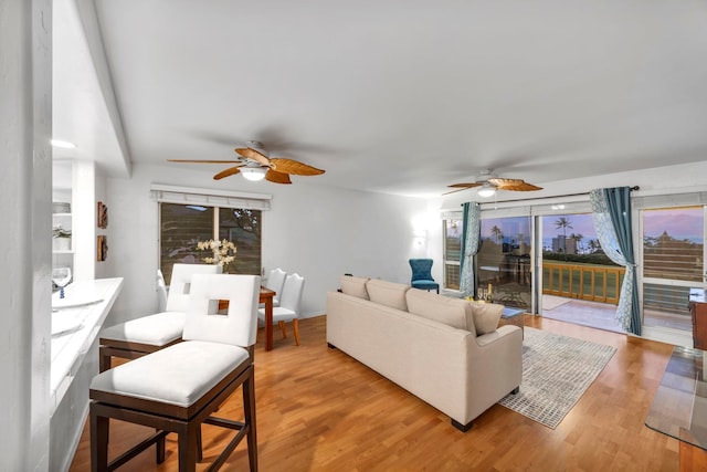 living room with ceiling fan, plenty of natural light, and hardwood / wood-style floors