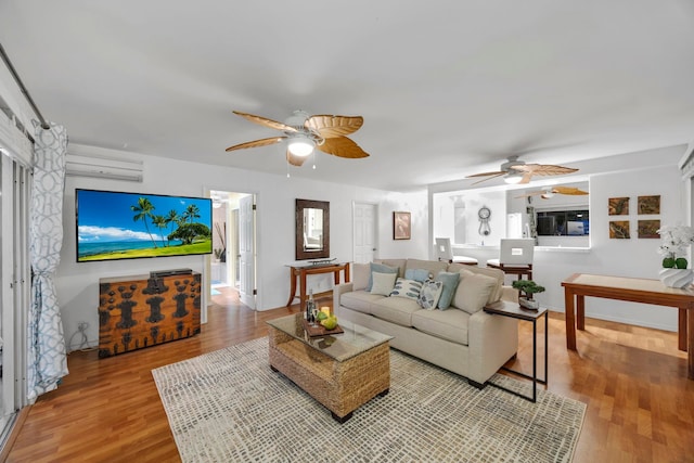 living room featuring ceiling fan, wood-type flooring, and a wall mounted AC