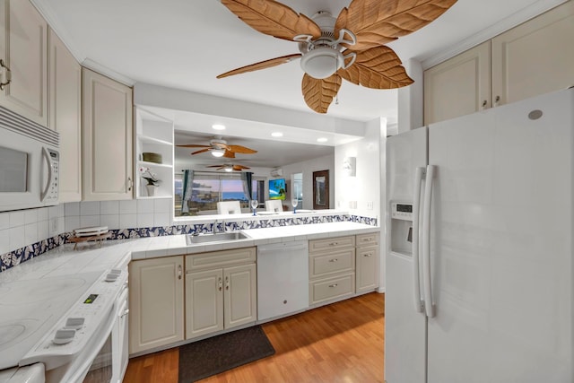 kitchen featuring tile counters, tasteful backsplash, white appliances, light hardwood / wood-style flooring, and sink