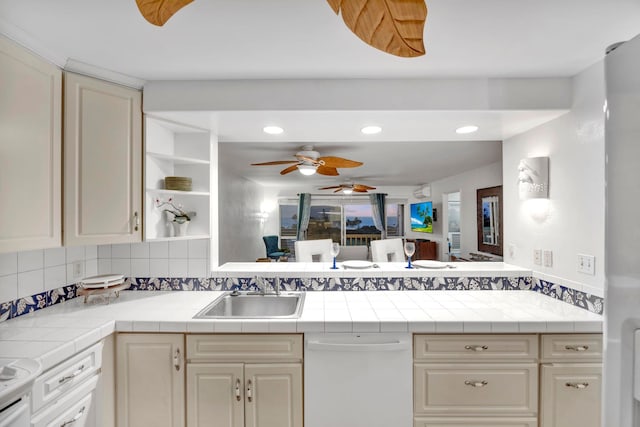 kitchen with backsplash, dishwasher, tile countertops, sink, and cream cabinets