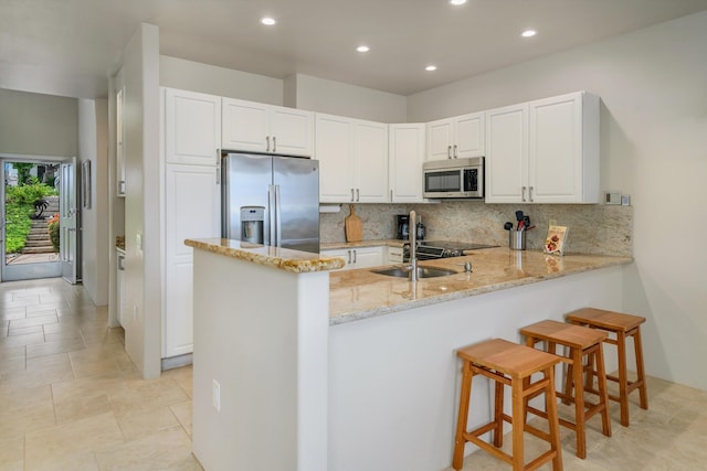3950 Kalai Waa St Unit R 103, Kihei, HI 96753 - kitchen with stainless steel appliances, a peninsula, recessed lighting, tasteful backsplash, and white cabinets