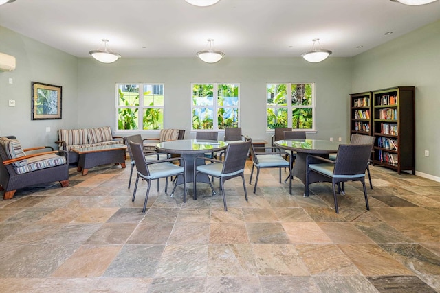 3950 Kalai Waa St Unit R 103, Kihei, HI 96753 - dining space featuring stone tile floors, healthy amount of natural light, and a wall unit AC