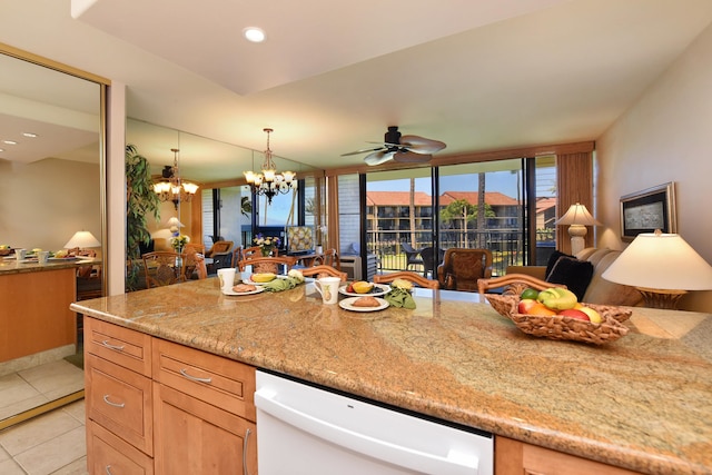 kitchen with hanging light fixtures, white dishwasher, ceiling fan with notable chandelier, light stone counters, and light tile floors