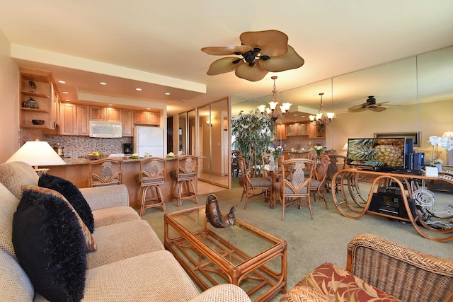 living room with ceiling fan with notable chandelier