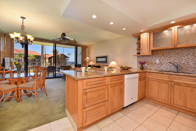 kitchen with backsplash, white dishwasher, light colored carpet, and kitchen peninsula