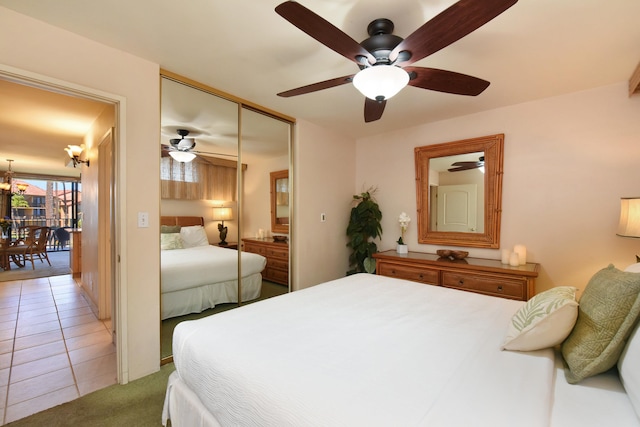 tiled bedroom with ceiling fan and a closet