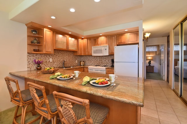 kitchen with light tile flooring, white appliances, tasteful backsplash, and sink