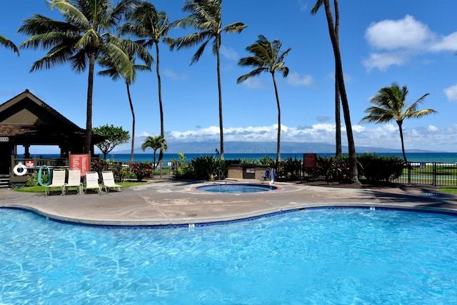 view of swimming pool featuring a water view, a hot tub, and a gazebo