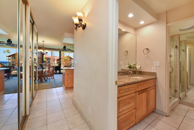 bathroom with ceiling fan with notable chandelier, tile floors, and vanity