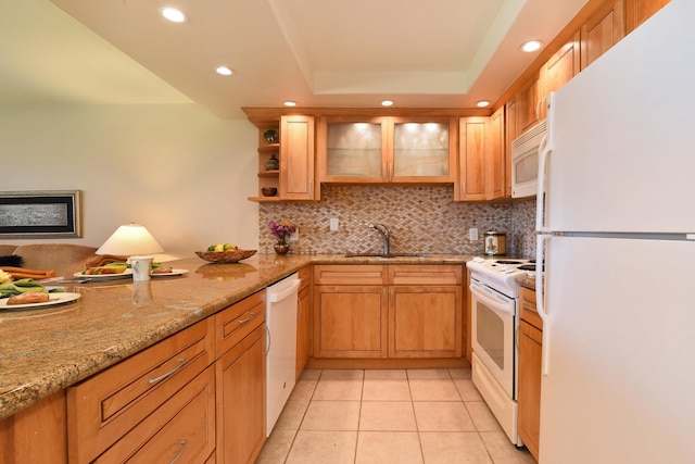 kitchen with white appliances, a tray ceiling, backsplash, light tile floors, and sink