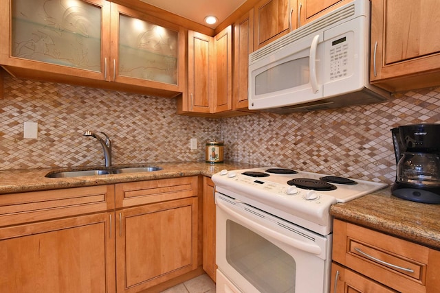 kitchen with sink, white appliances, tasteful backsplash, light tile flooring, and stone counters