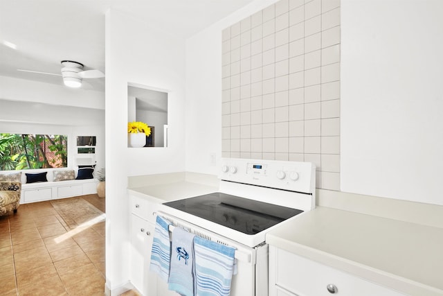 kitchen with white cabinets, light tile patterned flooring, ceiling fan, and white range with electric stovetop