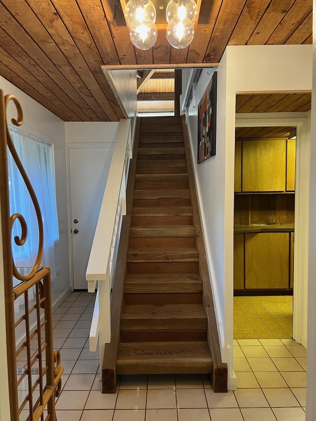 stairs with tile patterned floors and wooden ceiling