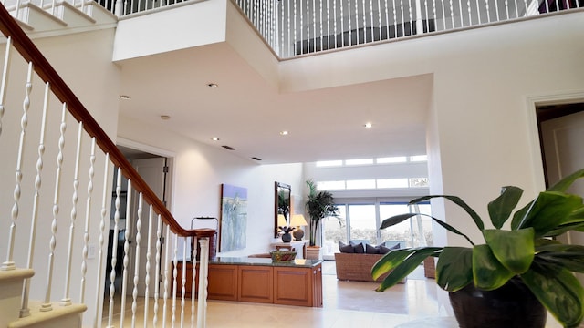 entryway featuring stairway, light tile patterned flooring, a towering ceiling, and recessed lighting