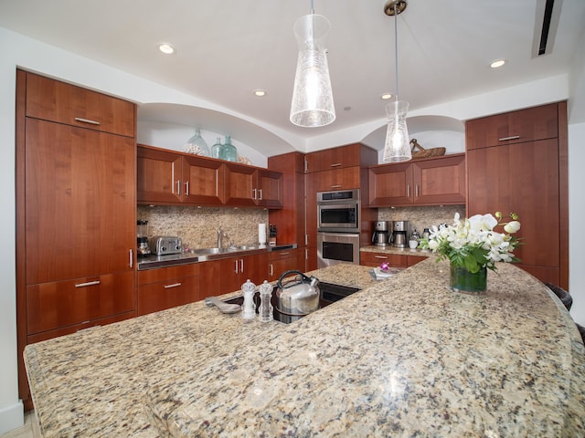 kitchen with sink, double oven, black cooktop, decorative light fixtures, and decorative backsplash