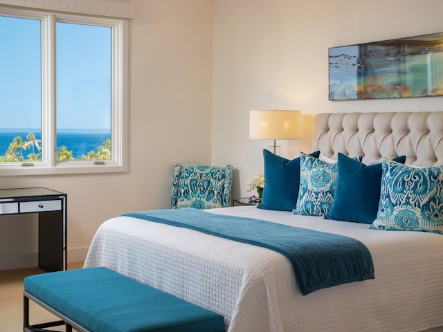 carpeted bedroom with a water view