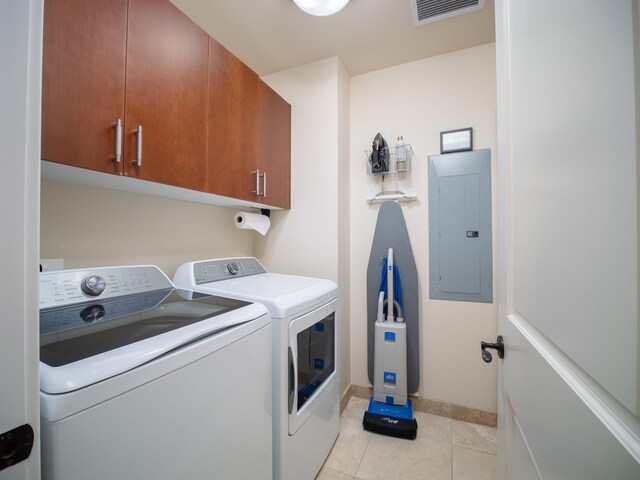 clothes washing area featuring light tile patterned floors, cabinets, separate washer and dryer, and electric panel