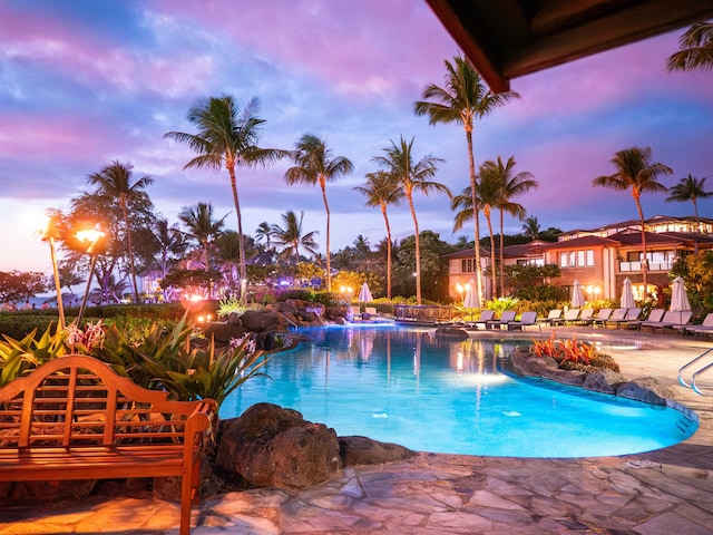 pool at dusk with a patio area