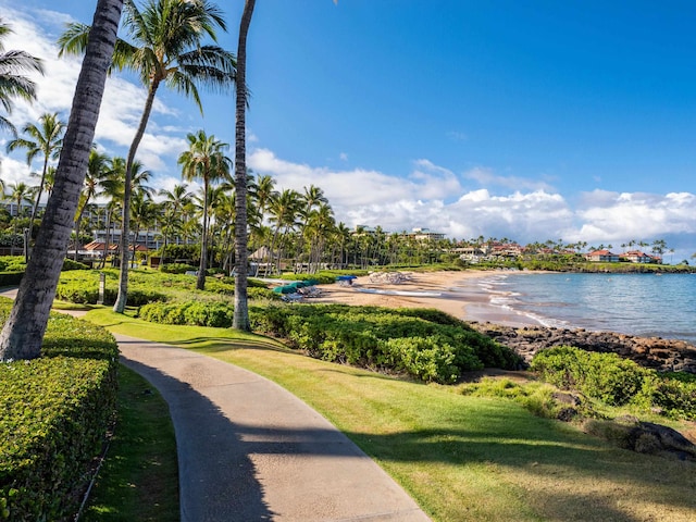 view of home's community with a lawn and a water view