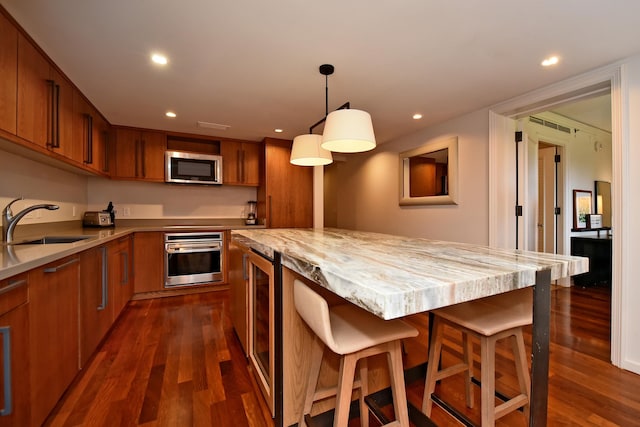 kitchen featuring sink, wine cooler, dark hardwood / wood-style floors, appliances with stainless steel finishes, and decorative light fixtures