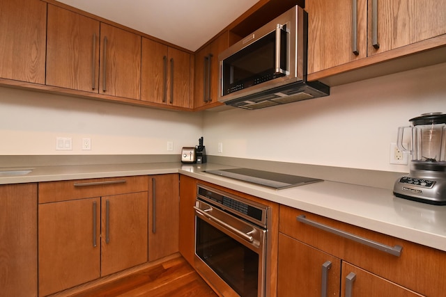 kitchen featuring stainless steel appliances and dark hardwood / wood-style floors