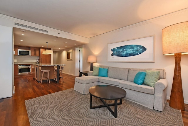 living room featuring dark hardwood / wood-style flooring and crown molding