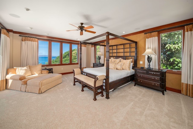 carpeted bedroom with ceiling fan, a water view, crown molding, and multiple windows