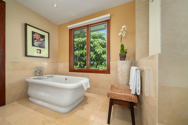 bathroom featuring tile walls, tile patterned flooring, and a tub