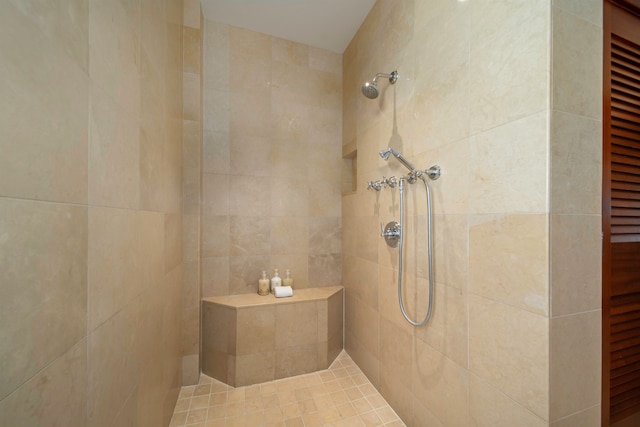 bathroom with a tile shower and tile walls