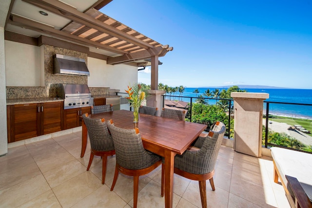 view of patio with a water view, an outdoor kitchen, a balcony, a view of the beach, and a grill