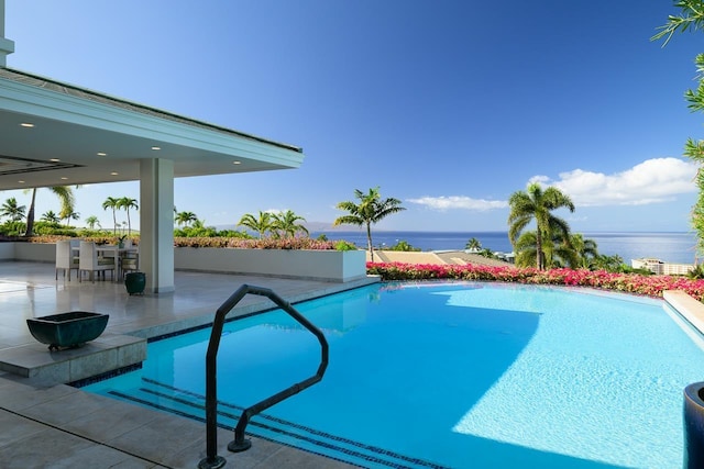 view of pool featuring a patio area and a water view