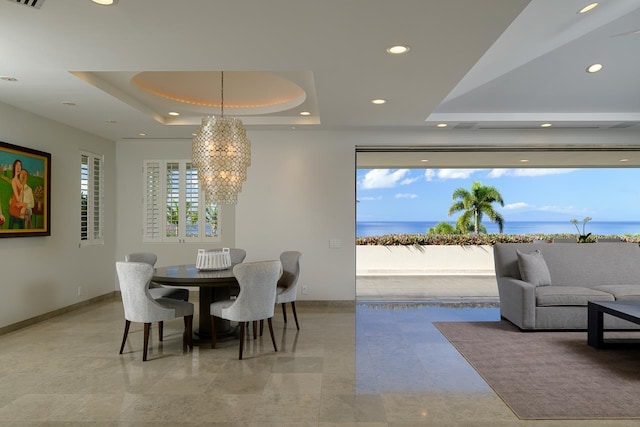 dining space with a chandelier and a tray ceiling