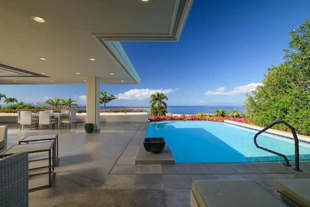 view of pool with a patio area and a water view