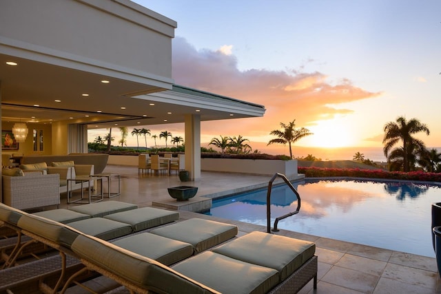 pool at dusk with a patio area