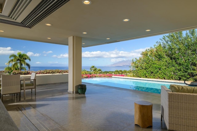 view of pool with a water view and a patio area