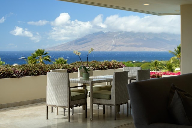 view of patio / terrace with a balcony and a water and mountain view