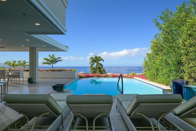 view of pool with a patio area and a water view