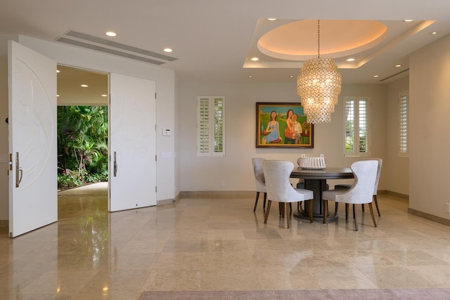 dining space featuring a tray ceiling and a notable chandelier