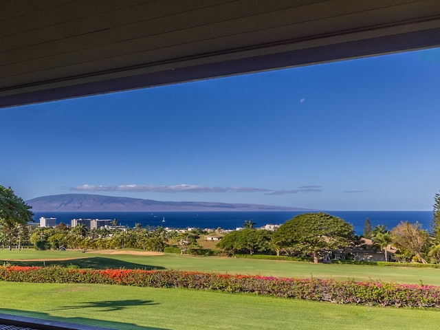 view of property's community with a water and mountain view and a lawn