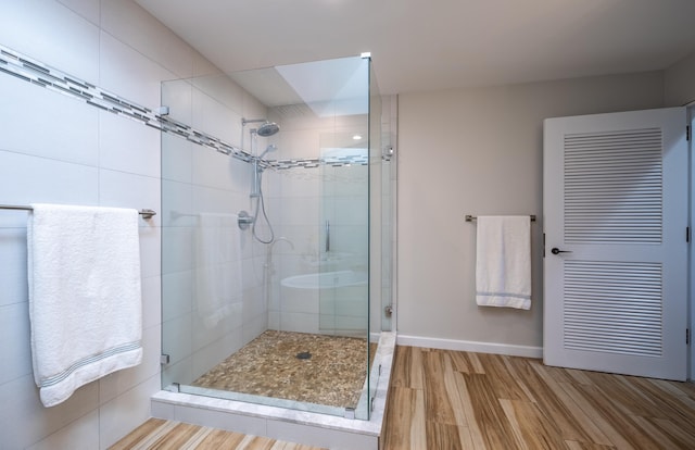 bathroom featuring hardwood / wood-style flooring and a shower with shower door