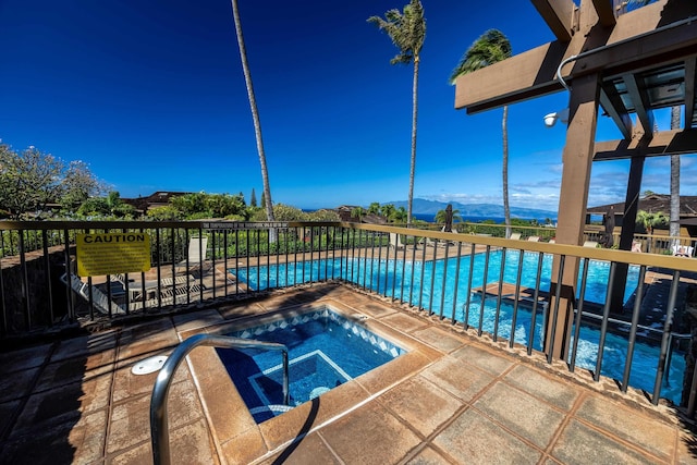 view of pool with a mountain view, a patio, and a hot tub