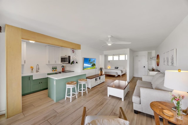 living room featuring light wood-type flooring and ceiling fan