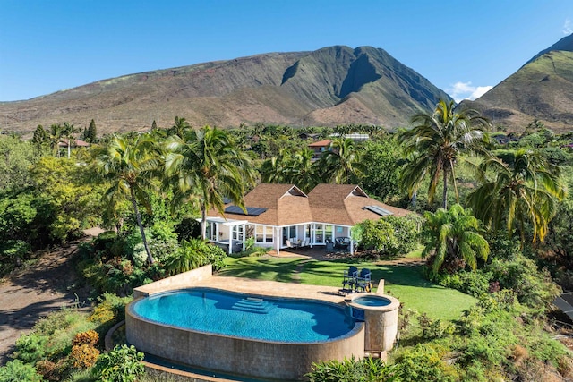 view of pool featuring a patio area, a mountain view, and a yard