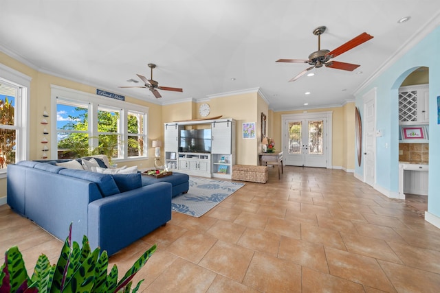 tiled living room featuring plenty of natural light, ceiling fan, ornamental molding, and french doors