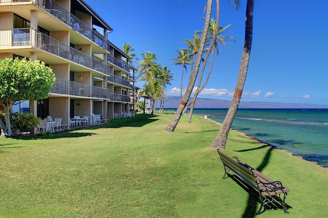 view of community featuring a lawn and a water view