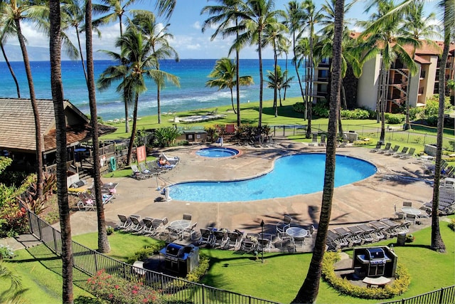 view of swimming pool featuring a patio and a water view