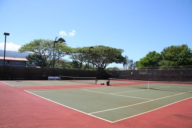 view of tennis court with basketball hoop