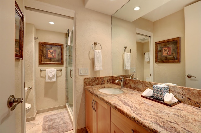 bathroom with tile patterned floors, vanity, toilet, and a shower with shower door